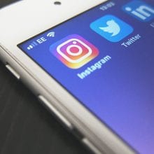 Smart phone with social media apps shown. What are the benefits of social media for businesses?